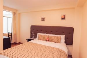 库斯科Hotel Las Quenas的一间卧室配有一张大床和棕色床头板