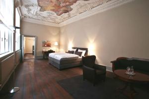 吕贝克安诺1216酒店的一间卧室设有一张床和格子天花板