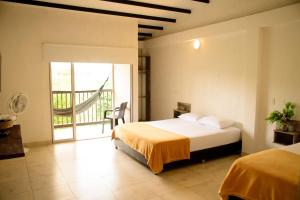 金巴亚Finca Hotel Loma Verde的一间卧室设有一张床和一个阳台
