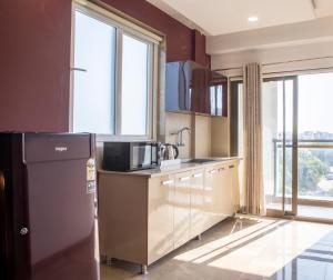 古尔冈Perch Service Apartment DLF Cyber City的厨房配有冰箱和一些窗户。