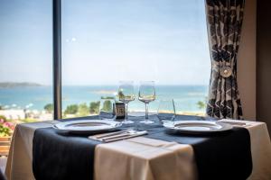 土鲁万布兹讷维兹地区酒店的一张桌子和酒杯,享有海景