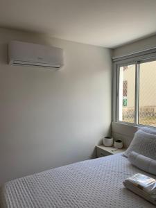 坎博里乌Encanto dos Mares - Apartamento premium 4的白色的卧室设有床和窗户