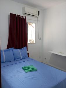 马拉戈日Condominio Oliveira的一间卧室配有一张蓝色的床,上面有绿毛巾