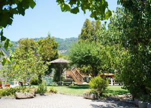 雷森迪Quinta Da Porta Caseira的一个带桌子和遮阳伞的花园