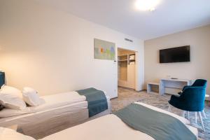 巴克乌Fiald Hotel & Spa的酒店客房设有两张床和电视。