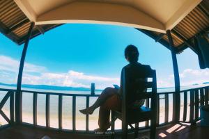 班泰帕岸岛金滩度假酒店的坐在椅子上,望着大海的人