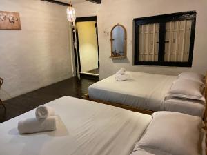 马六甲马六甲拉央拉央宾馆的带三张床和镜子的客房