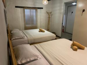 马六甲马六甲拉央拉央宾馆的一间卧室配有两张床和镜子