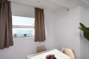 罗列特海岸Apartamentos Venecia的一间带桌子和窗户的用餐室