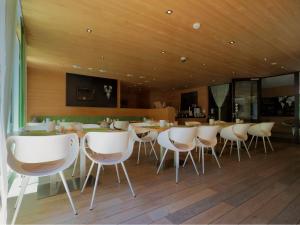 达米尔斯Aparthotel Alpinresort Damüls的一间配备有白色椅子和桌子的用餐室