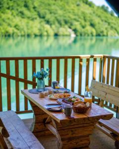JablanicaGlamping Bagrem的一张带食物的野餐桌,享有湖景