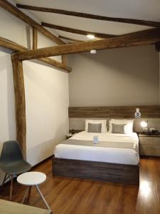 昆卡Hotel Raymipampa的一间卧室配有一张大床和一把椅子