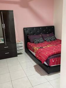 拉布安DinDas Family Stay @ Labuan的一间卧室配有黑色的床和梳妆台