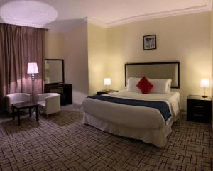 吉赞فندق البروج的酒店客房设有一张带红色枕头的大床