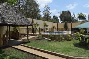 阿鲁沙Stasumo House Arusha的一个带围栏和游泳池的后院