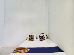 ParitSPOT ON 91834 Sg 99 Homestay Syariah的一张位于房间的床,上面有两个枕头