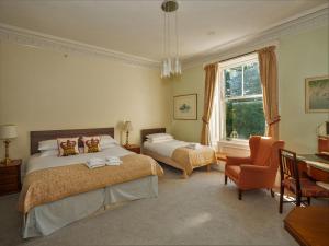 达尔比蒂克罗亚德别墅酒店的一间卧室设有两张床、一张桌子和一个窗口。
