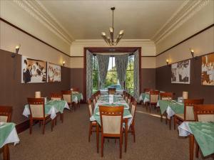 达尔比蒂克罗亚德别墅酒店的用餐室配有绿色桌椅和吊灯。
