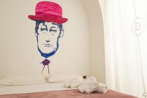 那不勒斯Totò Style Apartment的墙上挂着帽子的人的画