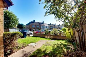 埃奇韦尔Welshside - Modern One Bedroom House, Welsh Harp, NW London By MDPS的一个带栅栏的院子和一个带雨伞的房子