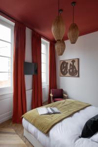 里昂MiHotel Blandan的一间卧室设有一张带红色墙壁和窗户的床。