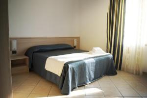 阿尔巴Residence La Quiete的一间卧室配有一张带桌子和窗户的床
