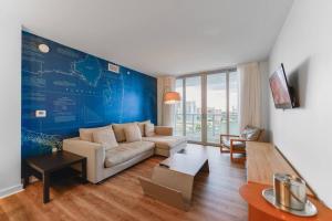 哈兰代尔海滩Cozy 1BR Condo Beachwalk Resort的带沙发和蓝色墙壁的客厅