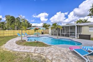 Merritt IslandMerritt Island Oasis with Pool about 7 Mi to Beach!的一个带躺椅的游泳池以及一座房子