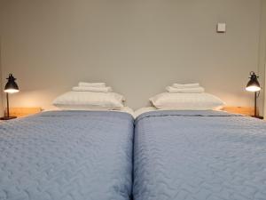 纳尔瓦Narva Port Hostel的两张床,上面有白色的床单和毛巾