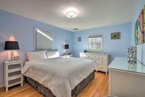 伍德伯里Family-Friendly Woodbury Home with Yard and Deck!的一间卧室设有蓝色的墙壁、一张床和一张书桌