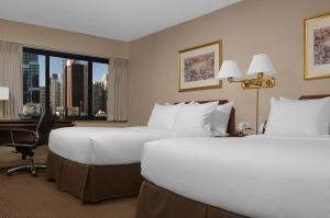 纽约曼哈顿时代广场酒店的酒店客房设有两张床、一张书桌和一个窗户。