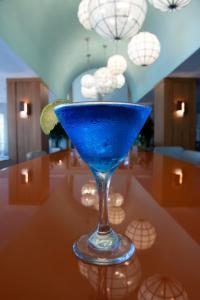 巴拿马城海滩Bluegreen's Bayside Resort and Spa at Panama City Beach的坐在桌子上喝的蓝色饮料