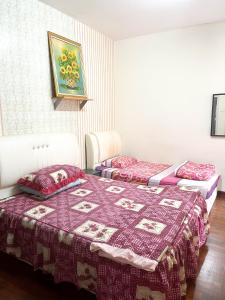 麻坡Muar Homestay [Located at Sabak Awor Seafood Court]的宿舍间内的两张床,床上有被子