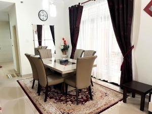 麻坡Muar Homestay [Located at Sabak Awor Seafood Court]的一间带桌椅和时钟的用餐室