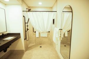 麦克默里堡Baymont by Wyndham Fort McMurray的带淋浴、盥洗盆和镜子的浴室