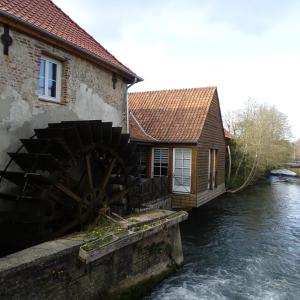 RentyLe gîte de l'AA的河边一座有水磨坊的建筑