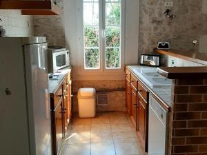 尚尼耶Gîte Champniers, 3 pièces, 4 personnes - FR-1-653-198的厨房配有水槽、冰箱和窗户。