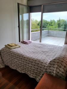 希洪Chalet en Somió con finca independiente的一间卧室设有一张床和一个大窗户