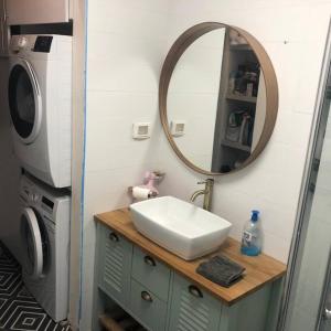赖阿南纳Stunning four bedroom duplex in central Raanana的一间带水槽和镜子的浴室以及一台洗衣机