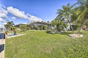 珊瑚角Cape Coral Home with Gulf and Dock Access的一座房子前面有棕榈树的院子