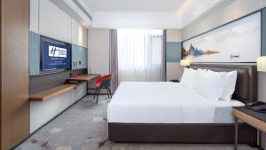 沧州沧州高新智选假日酒店的一间酒店客房,配有一张床和一台电视