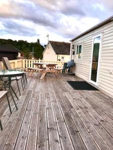 阿维莫尔Summer Breeze的木甲板,配有桌子和野餐桌