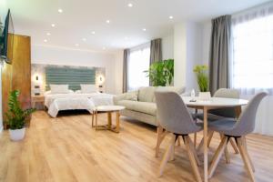 拉拉古纳Laguna Home & Suites的客厅配有床和桌椅