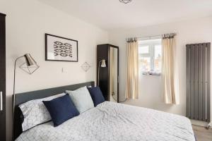 伯明翰Cosy Brand new spacious 1 bed luxury apartment的一间卧室配有一张带蓝色枕头的床和一扇窗户。