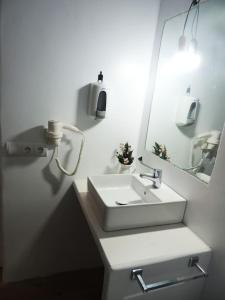 拉萨维纳Suite La Savina Formentera con vistas al mar的白色的浴室设有水槽和镜子