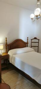 阿玛考德佩拉Vivenda Miraflores的一间卧室配有一张床和一张带台灯的桌子