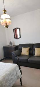 阿玛考德佩拉Vivenda Miraflores的客厅配有黑色沙发和镜子
