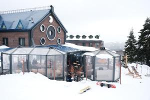 乌鲁达Oksijen Zone Hotel & Spa的建筑物前雪地中的滑雪小屋