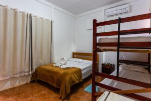 博尼图Pousada Chão de pedra的一间卧室配有两张双层床和一张带桌子的床。