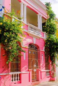 圣玛尔塔Casa Rosa - Alma Hotels的粉红色的房子,前面有一个门